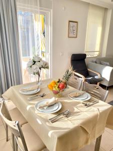 uma mesa com uma toalha de mesa branca e uma taça de fruta em Zerrin Hanım Apartments - 1 minute from Kleopatra Beach em Alanya