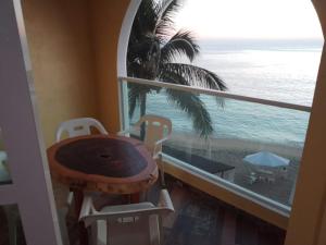 a table and chairs in a room with a view of the ocean at Hotelito Escondido in Manzanillo
