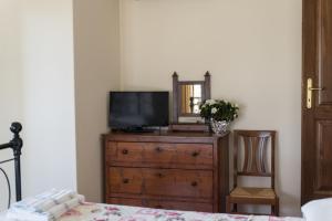 a bedroom with a dresser with a television and a mirror at La Maestà Tuscan Sun in Cortona
