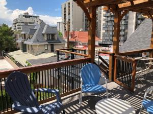 two chairs on a deck with a view of a city at Knight Campbell Carriage House in Denver