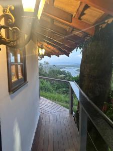 a wooden porch with a view of the ocean at Minas Em Marambaia in Rio de Janeiro