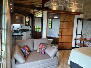 a living room with a couch and a kitchen at Minas Em Marambaia in Rio de Janeiro