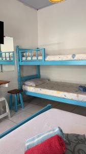 a room with two bunk beds and a table at Pousada Suítes Sete Mares in Guarujá