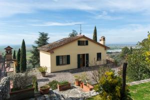 una pequeña casa blanca en la cima de una colina en La Maestà Tuscan Sun, en Cortona