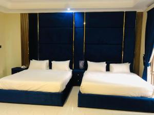 two beds sitting next to each other in a room at Royal Executive in Islamabad +17 photos