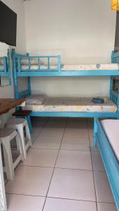 Pokój z 2 łóżkami piętrowymi i stołem w obiekcie Pousada Suítes Sete Mares w mieście Guarujá