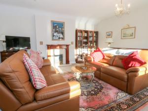 a living room with two couches and a fireplace at Molls Cottage in Nantwich