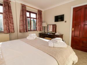 a bedroom with a large bed with towels on it at Molls Cottage in Nantwich