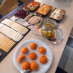 une table avec une plaque d'oranges et d'autres denrées alimentaires dans l'établissement Patrícia Panzió, à Bük