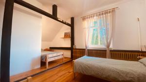 1 dormitorio con 2 camas y ventana en Rykowisko - Agroturystyka dla dorosłych, 