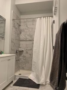 baño con ducha con cortina blanca en Spacious for groups 8mi from NYC, en Newark