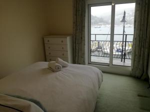 um quarto com uma cama e uma grande janela em Harbourside 2 em Dartmouth