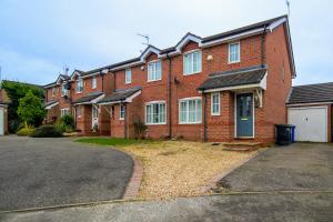 a large red brick house with a driveway at Charming 3 Bedroom, 2 Bathroom Home in Northampton - SKY TV included, Free Parking & WiFi by HP Accommodation in Northampton