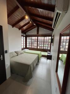 a bedroom with two beds in a room with windows at LAS ONDAS in Garopaba