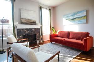 a living room with a red couch and a fireplace at Elegant Executive Escape 3800 sqft 5 bedroom home in Dallas