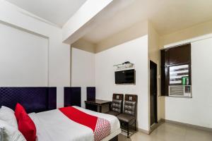 una camera con letto, scrivania e TV di 60800 Hotel Landlord a Rohtak