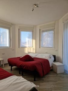 um quarto com 2 camas e 2 janelas em BeB Casa di Lia em Carugo