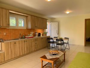 una cocina con armarios de madera, mesa y sillas en Sea melodies apartment 2, en Koroni