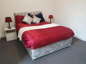 1 dormitorio con 1 cama grande de color rojo y 2 lámparas en Central Southampton Ocean Village, en Southampton