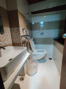 a bathroom with a sink and a toilet at ARTUS HOTEL in Mumbai