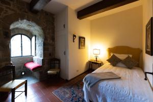 - une chambre avec un grand lit et une fenêtre dans l'établissement Castello e Borgo di Porciano, à Pratovecchio