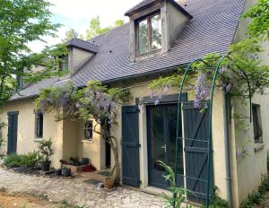 a house with a green door and purple flowers at Oak Wood - Olympic Villa in La Queue-lès-Yvelines