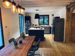 a kitchen with a wooden table and a refrigerator at Oak Wood - Olympic Villa in La Queue-lès-Yvelines