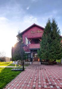 um edifício vermelho com uma entrada de tijolos em frente em Casa Nella em Brasov