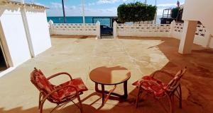 duas cadeiras e uma mesa num pátio com o oceano em Casa Gavina paseo marítimo de Altea em Altea