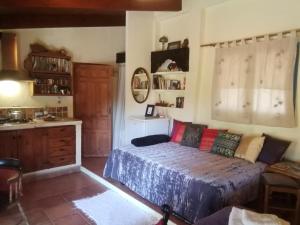 a bedroom with a bed and a kitchen with a sink at Eco Moyano Posada in Gaucín