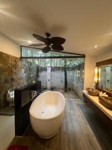 a large bathroom with a tub and a ceiling fan at Forest Villa at Dai Lai Resort in Ngọc Quang