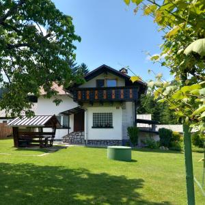 una casa con un patio verde delante de ella en Apartma Ella en Lovrenc na Pohorju