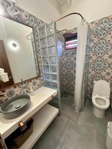 ein Badezimmer mit einem Waschbecken, einem WC und einem Spiegel in der Unterkunft Seaflower Boutique lodge in Providencia