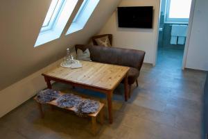 a living room with a wooden table and a chair at Haus Allgäu Wohnung Schwabennestle in Türkheim