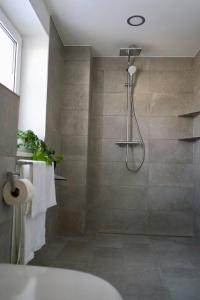 a bathroom with a shower with a tub and a sink at Haus Allgäu Wohnung Schwabennestle in Türkheim