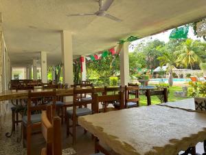 een restaurant met tafels en stoelen en een zwembad bij Hotel Puerta Chichen in Chichén-Itzá