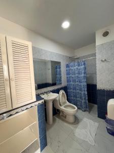 Hotel Zamba في جيراردو: حمام ازرق وابيض مع مرحاض ومغسلة