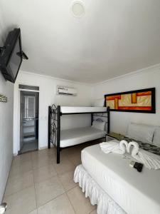 吉拉爾的住宿－桑巴酒店，一间带两张床的卧室和一台电视