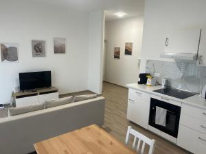 a kitchen with white cabinets and a sink and a tv at A Ca' di Giulietto in Albenga