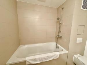 y baño con bañera blanca y toallas blancas. en Modern 150 m2 Maisonette - Private Garden & Free Parking, en Viena