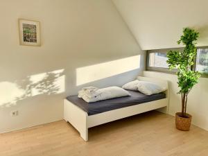 Cama pequeña en habitación con maceta en Modern 150 m2 Maisonette - Private Garden & Free Parking, en Viena