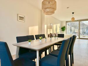 comedor con mesa y sillas azules en Modern 150 m2 Maisonette - Private Garden & Free Parking, en Viena