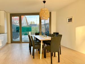 comedor con mesa y sillas en Modern 150 m2 Maisonette - Private Garden & Free Parking, en Viena