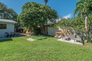 un patio con una mesa de ping pong y un árbol en Florida's finest living!, en North Palm Beach