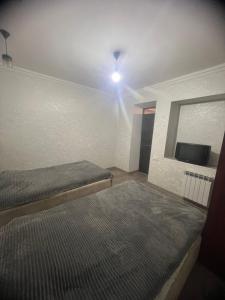 a bedroom with two beds and a flat screen tv at Miasnikyan Guest House in Yerevan