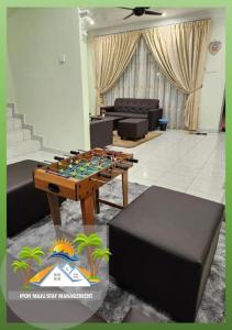 Galaxy Guest Home by Ipoh Maju Stay في ايبوه: غرفة معيشة مع طاولة كرة قدم وأريكة