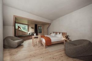 a bedroom with a bed and a table and chairs at Bühelwirt in San Giacomo