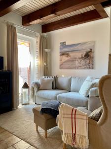 a living room with a couch and a table at Reetdachhaus in Seenähe, Ruhige Lage, Kamin & Terrasse in Seedorf