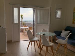un soggiorno con tavolo e sedie e un balcone di Apartamento La Vasca a El Puerto de Santa María