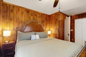 1 dormitorio con 1 cama grande y paredes de madera en Beneath the Banyans, en Bonita Springs